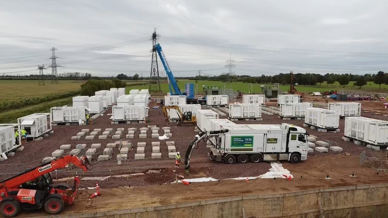 An aerial view of a data centre campus during enabling works, showing earthworks, access roads and open underground services trenching.
